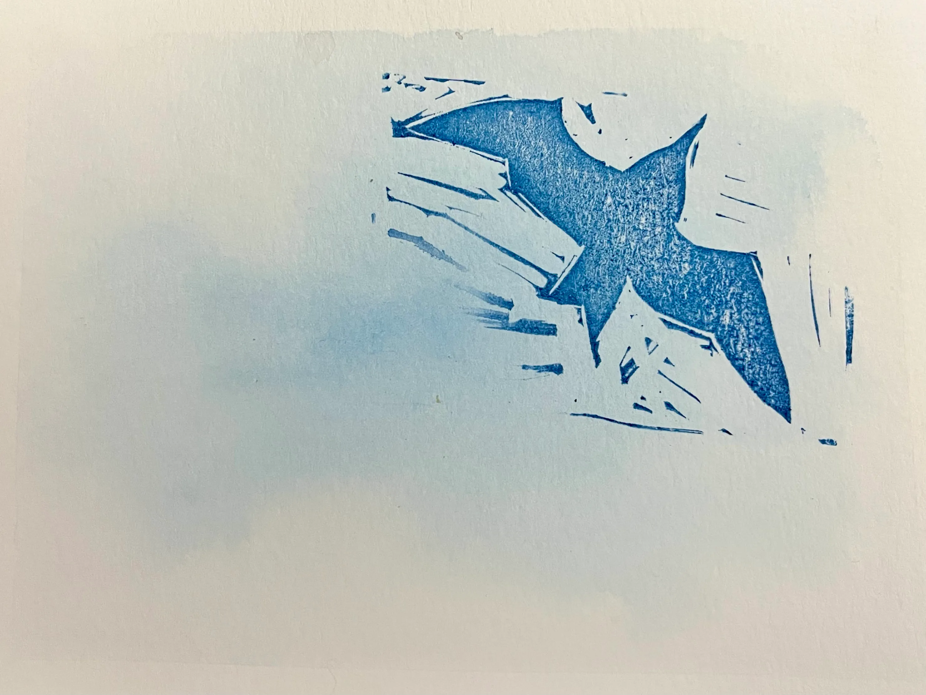 A seagull in blue ink stamped on top of a watercolour wash suggestive of a cloudy sky